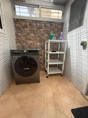 a washer and dryer in a room with a brick wall at Pavilion à la corniche de mohammedia proche plage & centre-ville in Mohammedia