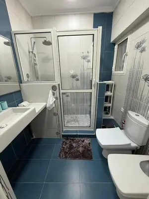 a blue and white bathroom with a shower and two toilets at Pavilion à la corniche de mohammedia proche plage & centre-ville in Mohammedia