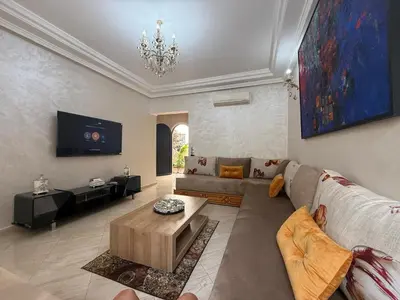 a living room with a couch and a tv at Pavilion à la corniche de mohammedia proche plage & centre-ville in Mohammedia