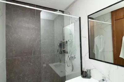 a bathroom with a shower with a mirror and a sink at Joli Studio au Cœur de CFC En Face Aeria Mall in Casablanca