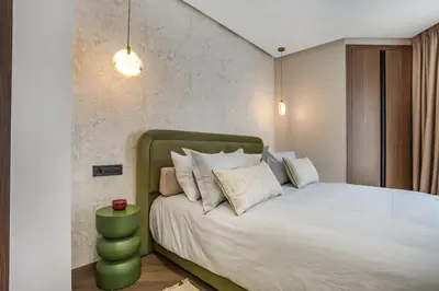 a bedroom with a white bed with a green headboard at Studio moderne in the Heart of Maarif Casablanca in Casablanca