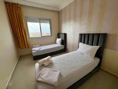 a small bedroom with a bed and a window at Urban Comfort Casablanca - 3BR Family Apartment in Casablanca