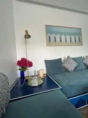 a living room with a blue couch and a table at The Blue Beach apartment- Residence Skhirat Beach2 in Skhirat