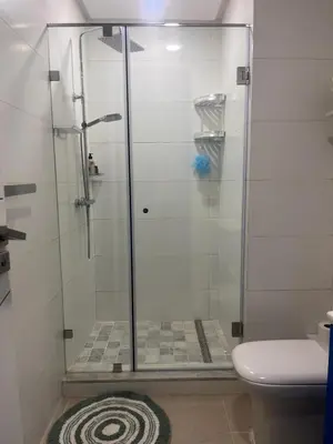 a shower with a glass door in a bathroom at The Blue Beach apartment- Residence Skhirat Beach2 in Skhirat