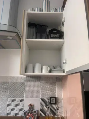 a kitchen with a cupboard with plates and dishes at The Blue Beach apartment- Residence Skhirat Beach2 in Skhirat
