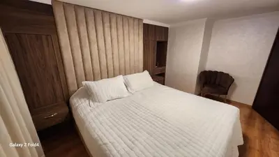 a bedroom with a white bed and a chair at Apartment in Harhoura in El Harhoura