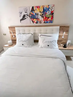 a bedroom with a white bed with two pillows at Votre Cocon Moderne - Central & tout confort in Casablanca