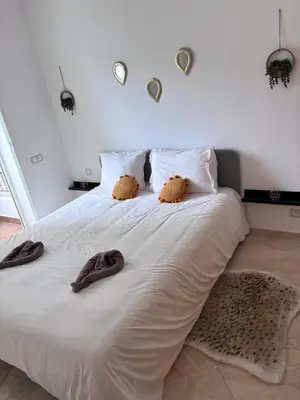 a white bed with two teddy bears on it at Shems Bouznika Residence Central & Cozy 2 Bedroom Apartment with Pool Bouznika in Bouznika