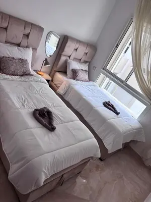 two beds sitting next to each other in a bedroom at Shems Bouznika Residence Central & Cozy 2 Bedroom Apartment with Pool Bouznika in Bouznika