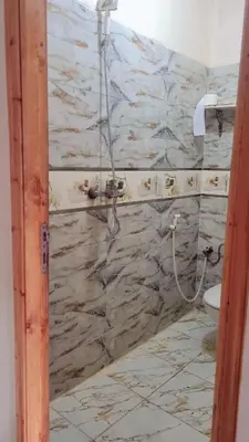 a bathroom with a stone wall with a shower at Chez binette in Casablanca
