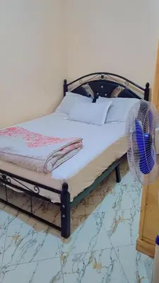 a bedroom with a bed with a fan on the floor at Chez binette in Casablanca