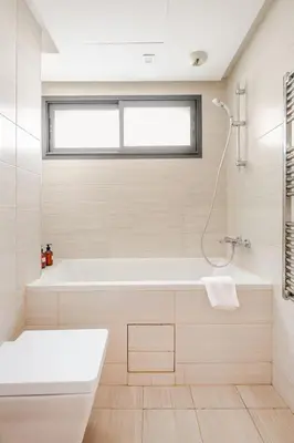 a white bathroom with a tub and a window at Harcay CFC in Casablanca