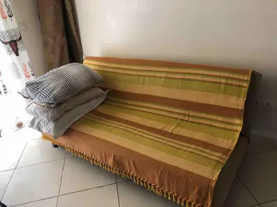 a bed with two pillows on top of it at Appart face à la mer Garden Beach Sidi Rahal plage in Sidi Rahal