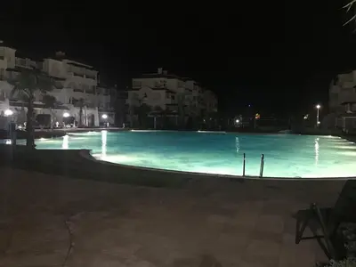 a large swimming pool at night with buildings at Appart face à la mer Garden Beach Sidi Rahal plage in Sidi Rahal