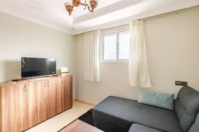 a living room with a couch and a flat screen tv at Layover Guest House - Studio Rabat City Center - 4th Floor in Rabat