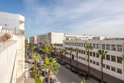 a city street with palm trees and buildings at Layover Guest House - Studio Rabat City Center - 4th Floor in Rabat