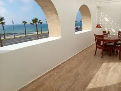 a dining room with a table and a view of the ocean at Apartment with terrace breathtaking ocean views in Rabat