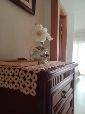 a vase and a book on a table with a flower at Apartment with terrace breathtaking ocean views in Rabat
