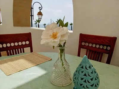 a vase with a white flower sitting on a table at Apartment with terrace breathtaking ocean views in Rabat