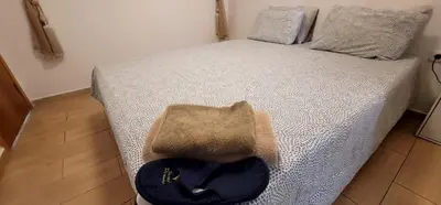 a bed with a hat sitting on top of it at Mansouria Appartement avec Piscine à proximité de la Plage in Mansouria