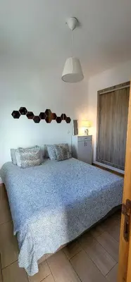 a bedroom with a large bed with a blue comforter at Mansouria Appartement avec Piscine à proximité de la Plage in Mansouria