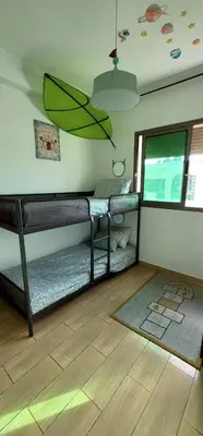 a room with two bunk beds and an umbrella at Mansouria Appartement avec Piscine à proximité de la Plage in Mansouria