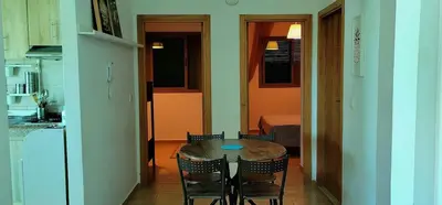 a kitchen with a table and chairs in a room at Mansouria Appartement avec Piscine à proximité de la Plage in Mansouria