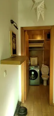 a small bathroom with a washing machine and a toilet at Mansouria Appartement avec Piscine à proximité de la Plage in Mansouria