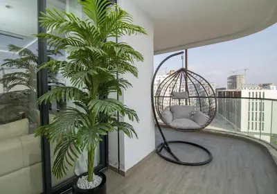a swing on a balcony with two palm trees at Skyline Retreat in Casablanca