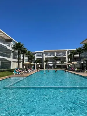 a large swimming pool with people in a resort at residence ramo flores in Bir Jedíd Saint-Hubert
