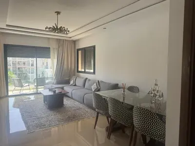 a living room with a couch and a table at Beautiful appart with pool in Bouznika