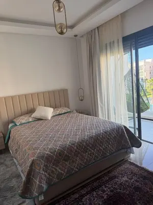 a bedroom with a bed and a large window at Beautiful appart with pool in Bouznika