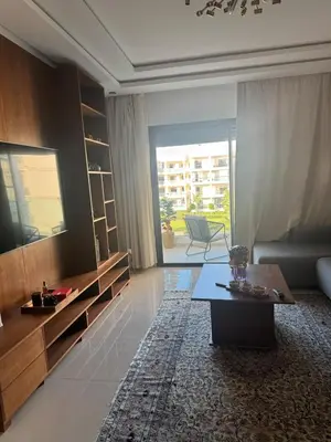 a living room with a couch and a table at Beautiful appart with pool in Bouznika
