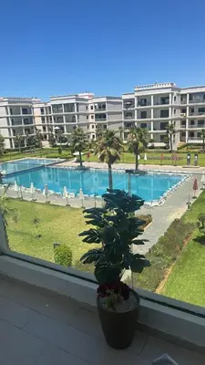 a view of a swimming pool from a window at Beautiful appart with pool in Bouznika