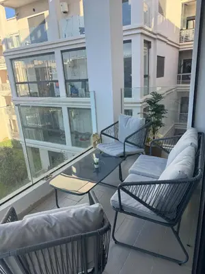 a balcony with chairs and a table on a building at Beautiful appart with pool in Bouznika