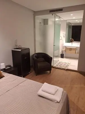 a bedroom with a bed and a chair and a bathroom at Holiday Appart in Casablanca