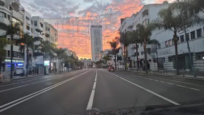 an empty city street with a sunset in the background at Holiday Appart in Casablanca