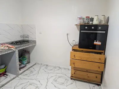 a kitchen with a black stove and a wooden dresser at Guesthouse Skhirat in Skhirat