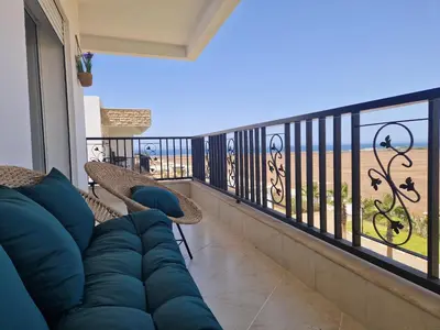 a living room with a couch on a balcony at Staycation Yakout in Mansouria