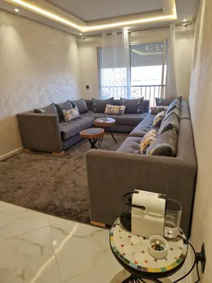 a living room with a couch and a table at Staycation Yakout in Mansouria