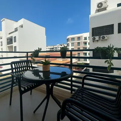 a balcony with a table and two chairs on a balcony at Scandi Design Central Casablanca in Casablanca