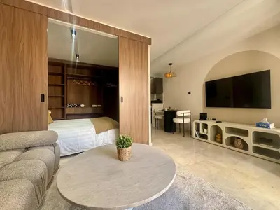 a living room with a couch and a bed and a tv at Scandi Design Central Casablanca in Casablanca