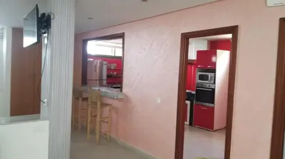 a kitchen with a red refrigerator and a bar with stools at Belle et spacieuse villa avec piscine privée in Casablanca