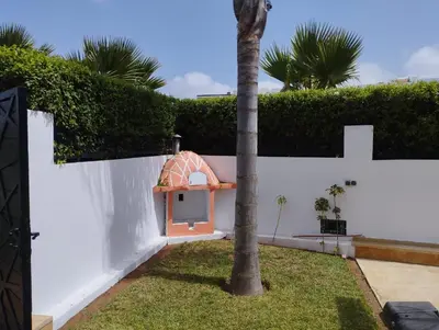 a white wall with a small dog house at Belle et spacieuse villa avec piscine privée in Casablanca