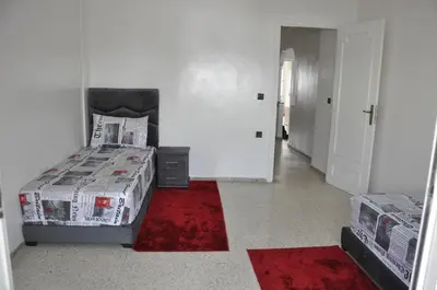 a bedroom with a bed and a red rug at Rental Apartment in Casablanca City Center in Casablanca