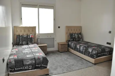 a bedroom with two beds and two windows at Rental Apartment in Casablanca City Center in Casablanca