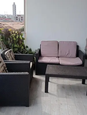 a couch and two chairs on a balcony at 2 Bedrooms Blanca Beach in Sidi Rahal