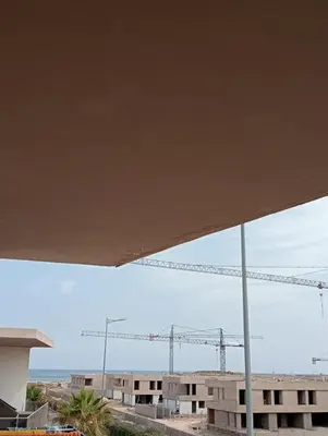 a view of a building with a crane in the background at 2 Bedrooms Blanca Beach in Sidi Rahal