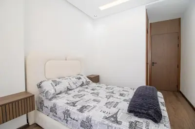 a white bedroom with a bed with a blanket at Modern Studio 5min CFC in Casablanca