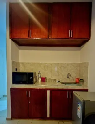 a kitchen with wooden cabinets and a microwave at Parisien Studio in Rabat